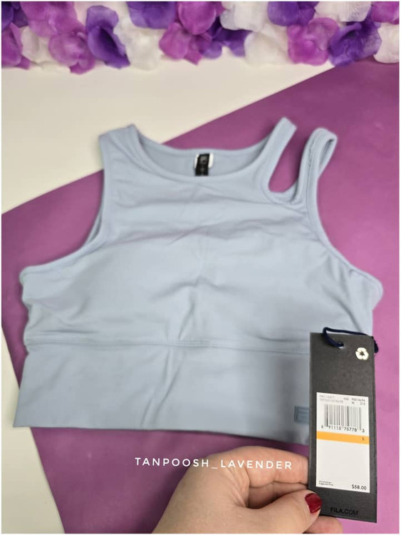 تصویر نزدیک از لوگوی برند فیلا روی نیمتنه آبی روشن